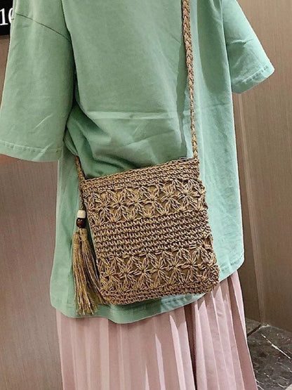 A niche high-end French cross-body straw bag with hand-woven off-white semi-circle hollow fresh tassel bag in summer