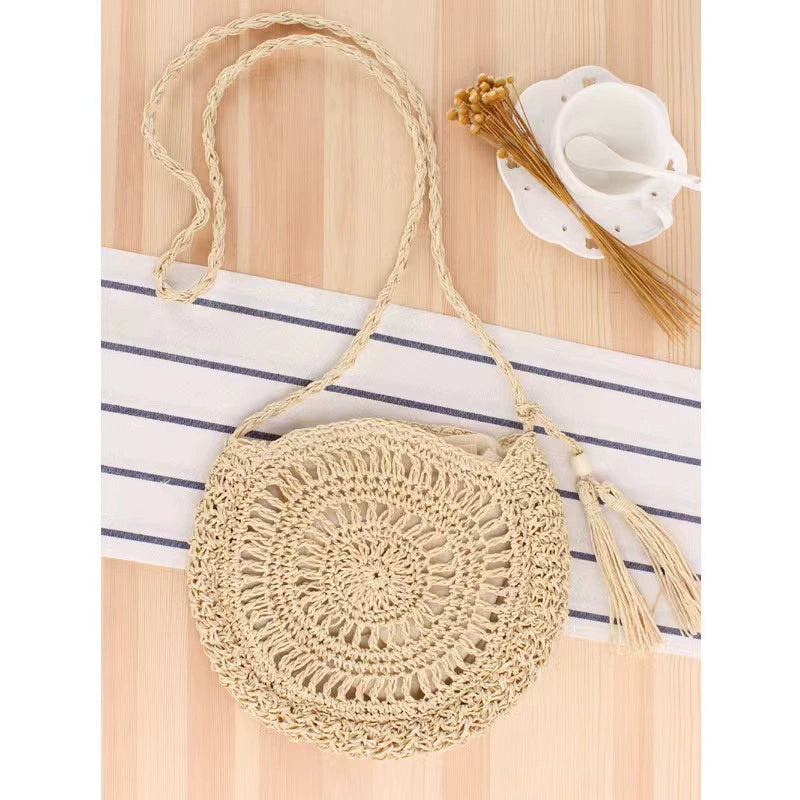 A niche high-end French cross-body straw bag with hand-woven off-white semi-circle hollow fresh tassel bag in summer