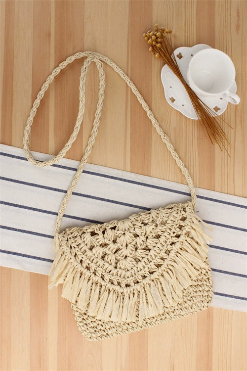 A niche high-end French cross-body straw bag with hand-woven off-white semi-circle hollow fresh tassel bag in summer