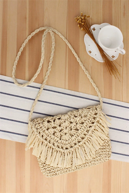 A niche high-end French cross-body straw bag with hand-woven off-white semi-circle hollow fresh tassel bag in summer