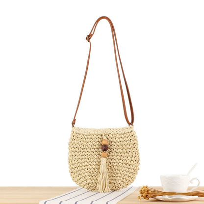 A niche high-end French cross-body straw bag with hand-woven off-white semi-circle hollow fresh tassel bag in summer