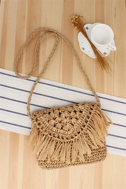 A niche high-end French cross-body straw bag with hand-woven off-white semi-circle hollow fresh tassel bag in summer