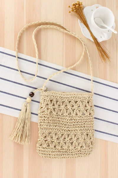 A niche high-end French cross-body straw bag with hand-woven off-white semi-circle hollow fresh tassel bag in summer